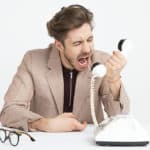 man shouting into telephone